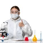 front-view-female-doctor-protective-suit-with-mask-using-microscope-white-background-health-pandemic-coronavirus