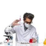 front-view-middle-aged-scientist-white-medical-suit-filling-injection-with-red-solution
